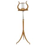 A Regency satinwood lyre form music stand, with hand painted decoration, with brass adjustable