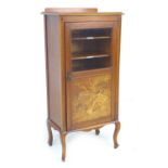 An Edwardian mahogany music cabinet with later top, the door with glass above a marquetry panel
