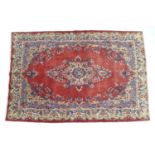 A Hamadan rug with red ground, central cream and blue medallion with conforming corners, floral