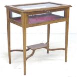 An Edwardian mahogany and inlaid vitrine, lift top, X stretcher, raised on slender tapering legs,