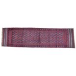 A Meshwari runner with dark red ground, six diamond patterns to white flower speckled field, with