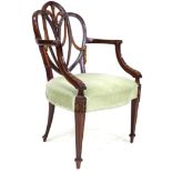 An early 19th century mahogany open arm chair, after a Hepplewhite design, with open trefoil heart