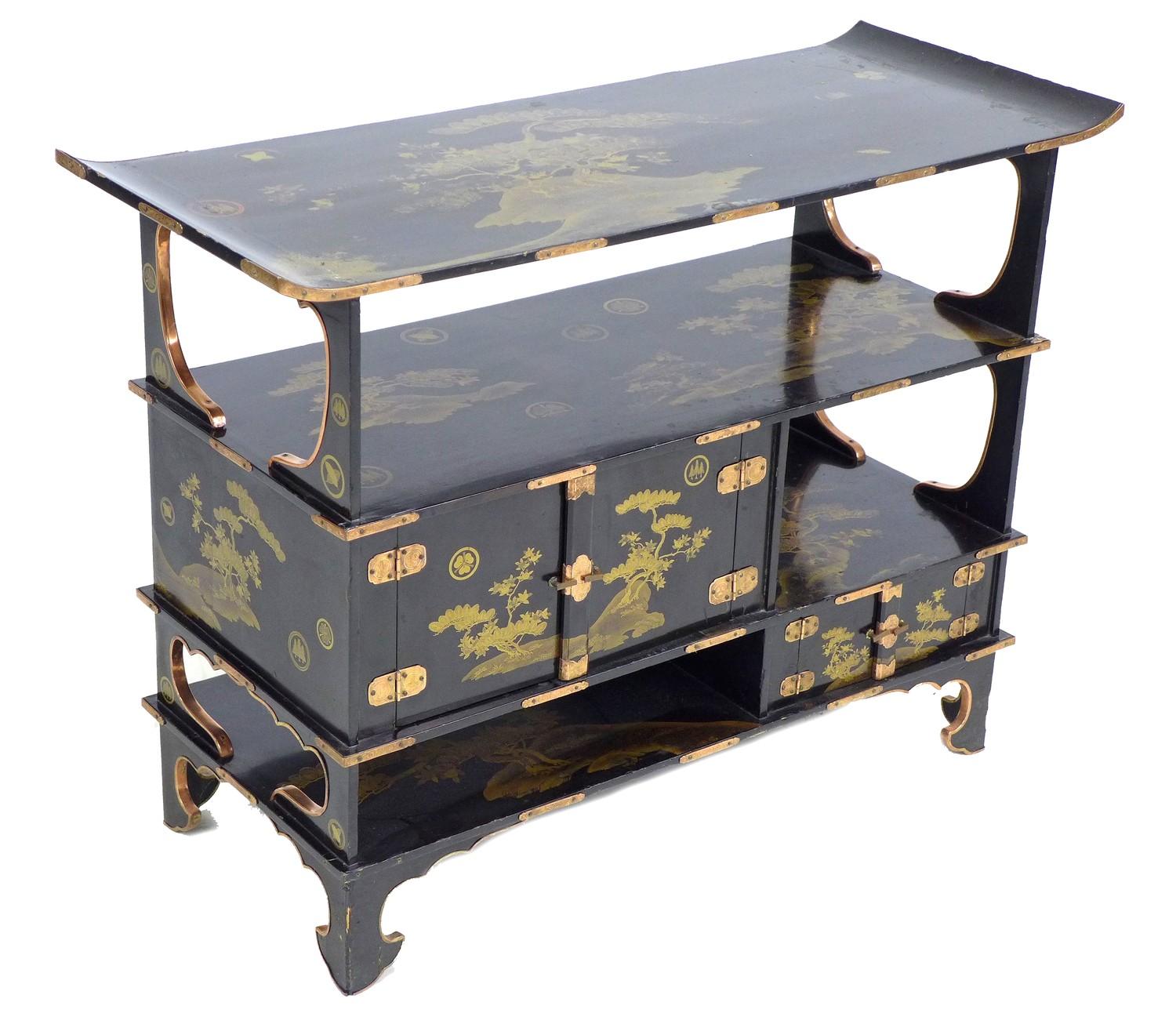 A low Japanese black lacquer shelf unit, Meiji period, with engraved copper mountings, decorated