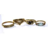 A group of four 9ct gold rings, comprising an aquamarine style ring, size I, a sapphire and