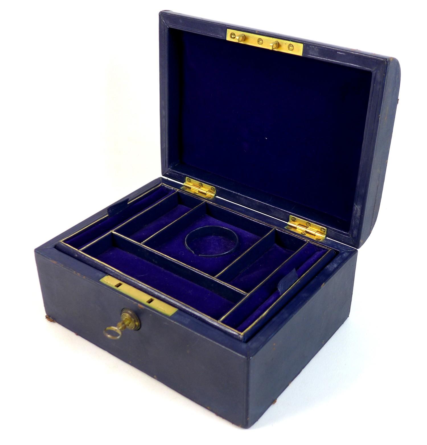 A late Victorian dark blue leather jewellery case, with gilt brass recessed handle with engraved