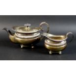 A late 19th/early 20th century Dutch silver teapot and milk jug, the teapot with foliate clasped