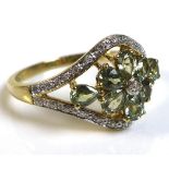 A 9ct gold, diamond and green stone ring, likely green amethyst, with central diamond to a flower