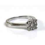 A 9ct white gold and diamond cluster ring, the central stone of approximately 0.08ct, surrounded