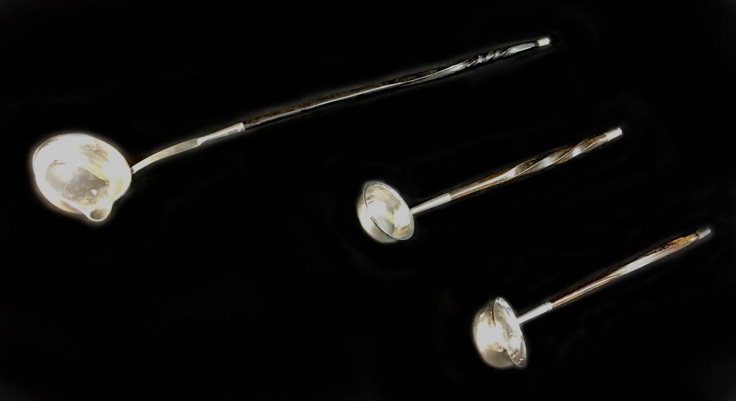 A William IV silver toddy ladle and two others, all with twisted whale bone handles, comprising a