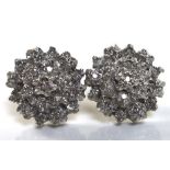 A pair of 9ct gold and white gold and diamond cluster earrings, of flowerhead design, with central