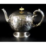 A Victorian silver teapot, of bullet form with scroll handle and foliate clasped spout, decorated