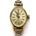A vintage Tissot 9ct gold lady's wristwatch, on a 9ct bracelet strap, oval brushed gold dial with
