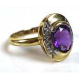 A 9ct gold, amethyst and diamond ring, the oval cut amethyst of approximately 7.3 by 6mm, with three