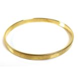 A 14K yellow gold bangle, of plain form, marked '585', 6.3cm internal and 6.7cm external diameter,