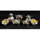 An Edwardian silver cruet set of gadroon bellied cauldron form, with fluted rims and silver gilt