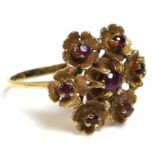 An 18ct gold and ruby ring of repeated flowerhead design, of six florettes, each set with a