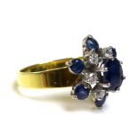 An 18ct gold sapphire and diamond flower head cluster ring, the central cobalt blue, oval cut