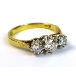 An 18ct gold and diamond three stone ring, the central round cut stone of approximately 0.25ct,