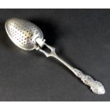An Edward VII silver tea infuser, fancy scroll decorated handle with two pronged support to the