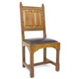 An Arts and Crafts style oak side chair, mid 20th century, with linenfold back, and seat upholstered