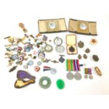 A pair of WWII War and Defence medals with miniatures, four military badges, a reproduction