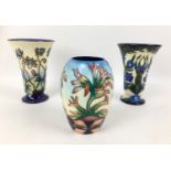 Three Moorcroft pottery vases, comprising two vases of tapering form, one in violet pattern with