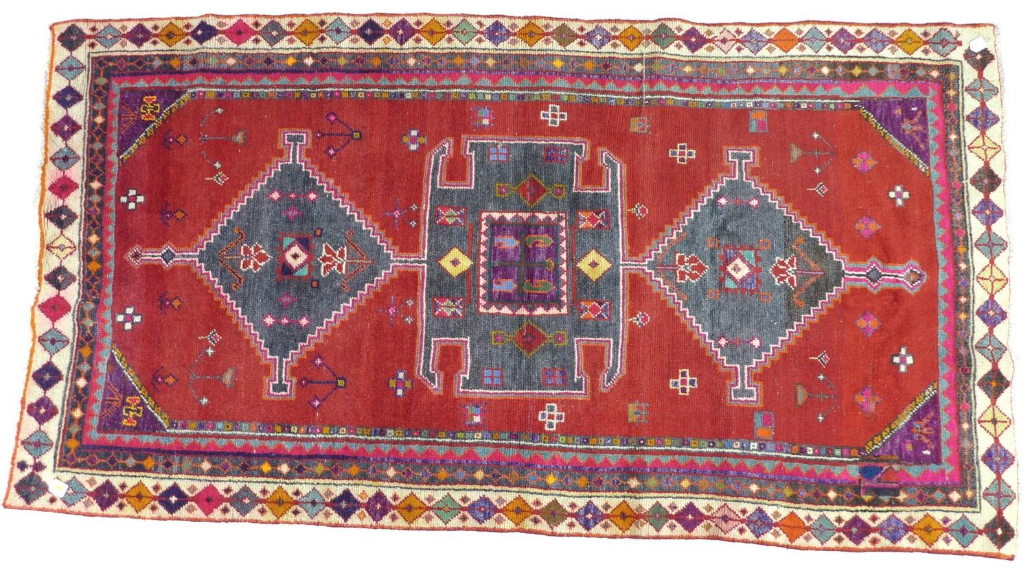 A Hamadan rug with red ground, geometric decoration, 245 by 130cm.