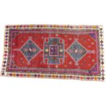 A Hamadan rug with red ground, geometric decoration, 245 by 130cm.