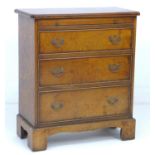 A modern reproduction bachelor's chest, in George III style, brushing slide over three drawers, on