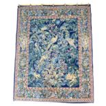 A modern tapestry wall hanging, depicting various birds and flowers, in greens, blues and golds,