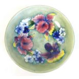 A Moorcroft bowl, the pale green ground decorated with Irises and blue violas, tublined and painted,