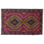 A Baluchi rug with red ground, two medallions in shade varying shades of brown with thin white and