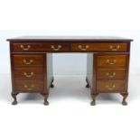 A mid 20th century mahogany twin pedestal desk, in Georgian Chippendale style, with eight drawers,