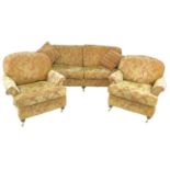 A modern three piece suite, red and gold foliate upholstery, comprising a three / four seater