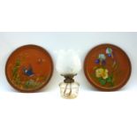 A pair of Watcombe Torquay terracotta chargers, one decorated with a swallow flying amongst reeds