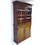 A late Victorian mahogany glazed bookcase, twin glazed doors enclosing shelves, the base section