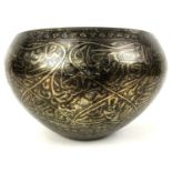 A 19th century Persian brass niello bowl, profusely decorated with Arabic calligraphic script