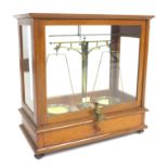 A set of mid 20th century laboratory scales, in four glass mahogany case, with brass fittings, and a