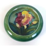 A Moorcroft lipped trinket bowl, tube line and painted, decorated with lillies, impressed