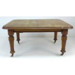 A Victorian extending oak dining table of square form, with carved baluster legs, with ceramic