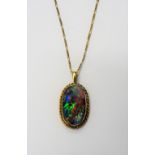 A gold mounted oval opal single stone pendant, decorated with a ropetwist border,