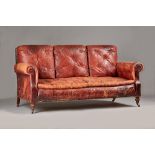 An early 20th century French rouge leather upholstered three seater sofa,