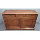 A 19th century French fruitwood side cabinet with three drawers over a pair of panel cupboards on