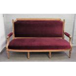 A Louis XVI style, gilt framed open arm sofa, with bow seat on tapering fluted supports,