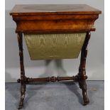 A late Victorian walnut work table with oval inset leather top on turned supports,
