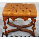 A Queen Anne style walnut footstool with tan buttonback leather upholstery, 59cm wide x 50cm high.