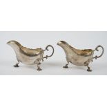 Two similar silver sauceboats, each having a scrolled handle,