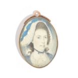 An oval portrait miniature of a lady wearing a bonnet,