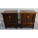 A pair of 20th century Eastern elm two door side cabinets on block supports, 61cm wide x 74cm high.