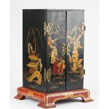 An Eastern lacquered two door table cabinet on parcel gilt bracket feet, 34cm wide x 53cm high.